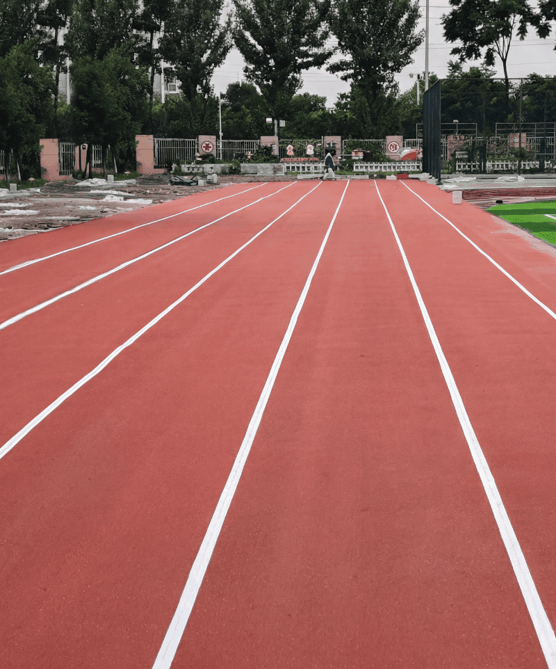 Liejama EPDM gumos danga bėgimo takui su pažymėtomis baltomis takelių linijomis lauko stadione.
