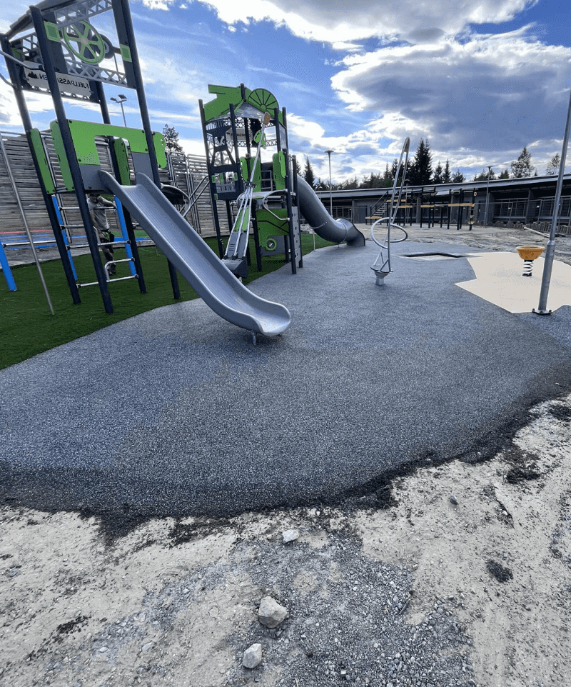 Liejama EPDM gumos danga vaikų žaidimų aikštelėje po čiuožyklomis ir laipynėmis, užtikrinanti saugumą ir amortizaciją kritimo atveju.