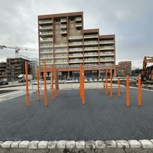 Paruošta lauko sporto aikštelė su liejama EPDM gumos danga ir įrengtais treniruoklių bei skersinių elementais.